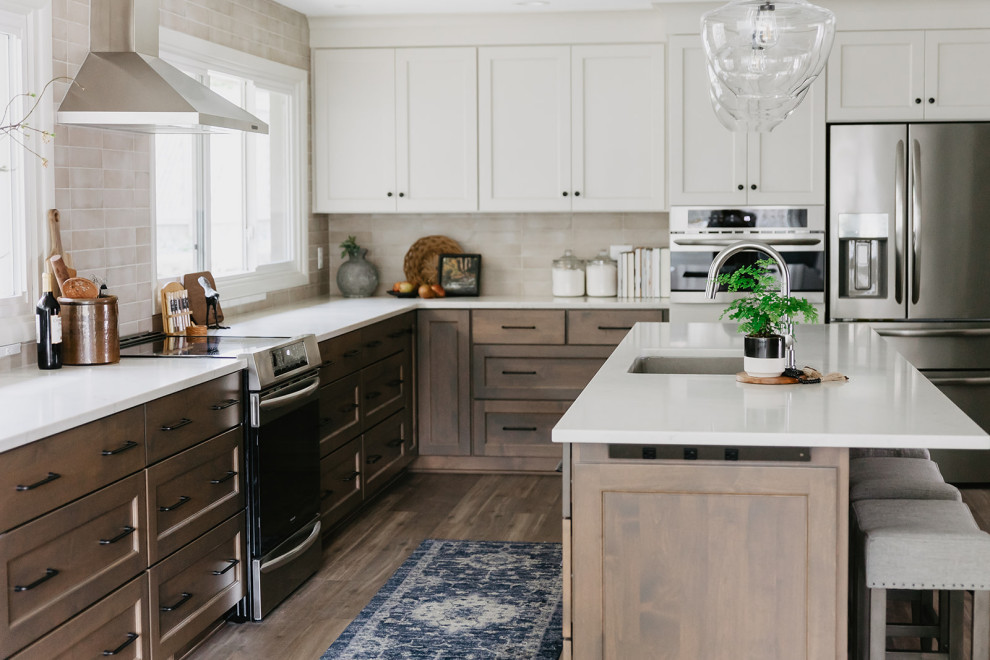 Example of a mid-sized transitional l-shaped vinyl floor and brown floor eat-in kitchen design with an undermount sink, shaker cabinets, medium tone wood cabinets, quartz countertops, beige backsplash, porcelain backsplash, stainless steel appliances, an island and white countertops