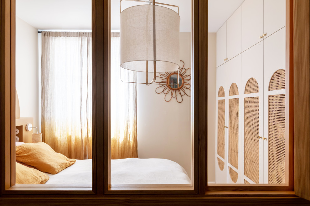 Kleines Hauptschlafzimmer mit beiger Wandfarbe, hellem Holzboden und braunem Boden in Paris