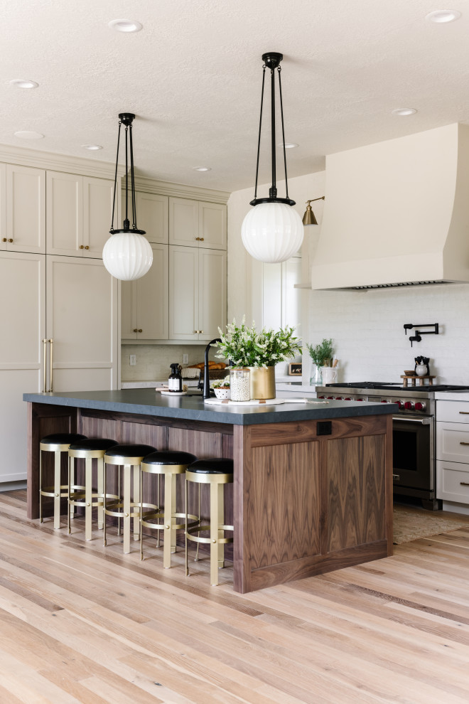 Foto di una cucina classica con ante in stile shaker, ante beige, paraspruzzi bianco, elettrodomestici in acciaio inossidabile, parquet chiaro, pavimento beige e top nero
