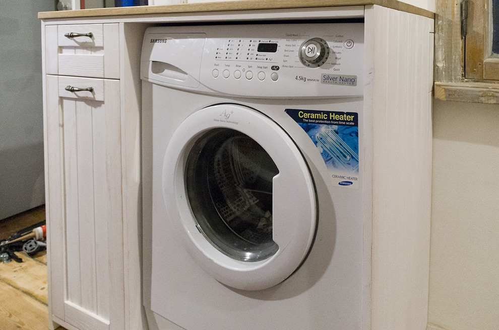 Small mountain style laundry room photo with recessed-panel cabinets