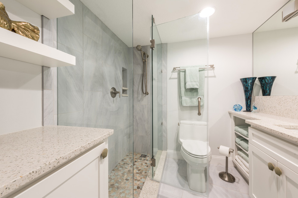 Design ideas for a large transitional 3/4 bathroom in Orlando with shaker cabinets, white cabinets, a corner shower, gray tile, porcelain tile, grey walls, porcelain floors, an undermount sink, recycled glass benchtops, grey floor, a hinged shower door and white benchtops.
