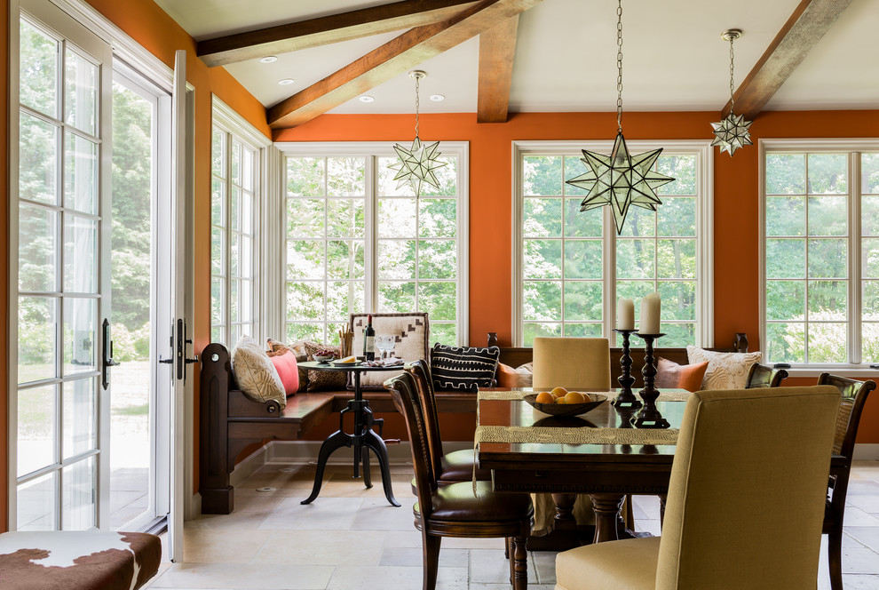 Inspiration for a mediterranean dining room in Boston with orange walls and limestone floors.