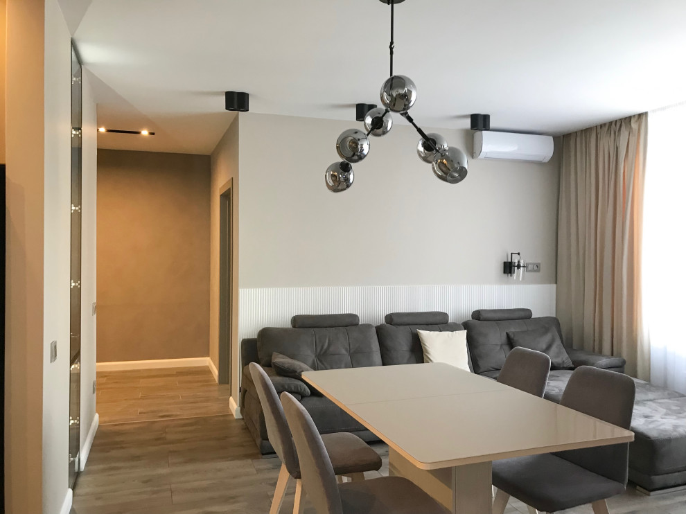 Mittelgroßes, Abgetrenntes Modernes Wohnzimmer in grau-weiß mit Hausbar, beiger Wandfarbe, Laminat, TV-Wand, braunem Boden und Wandpaneelen in Sonstige