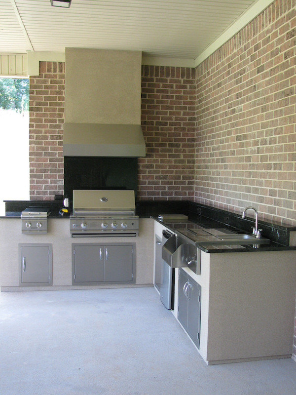 Photo of a large backyard patio in Atlanta with an outdoor kitchen, brick pavers and a roof extension.