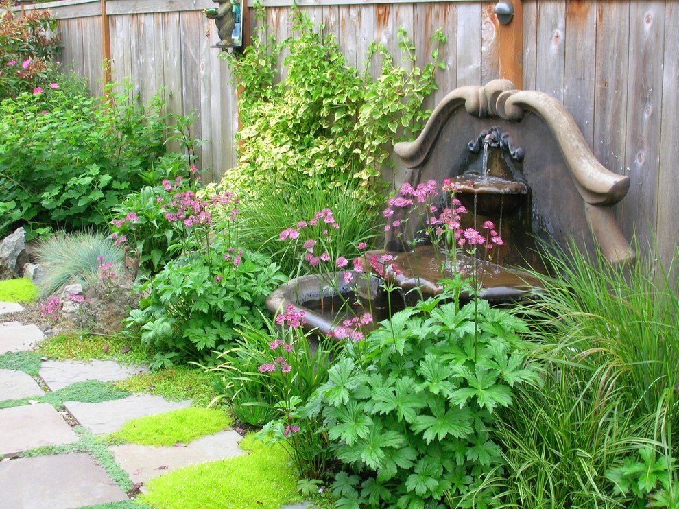 Large traditional courtyard garden in Seattle with a water feature and concrete pavers.