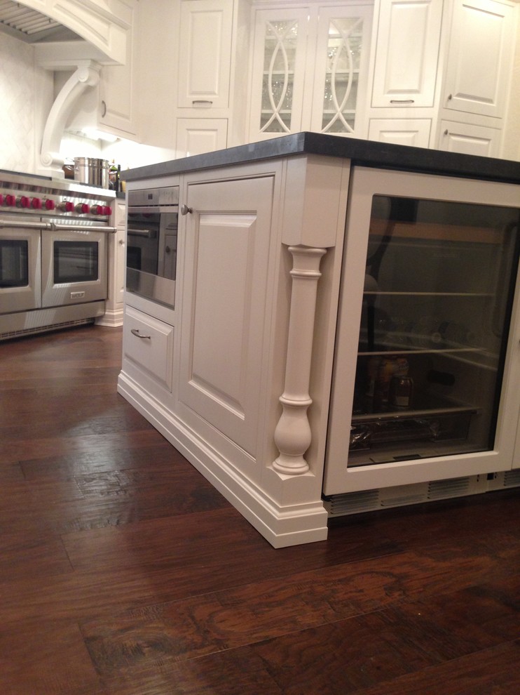 Kitchen - transitional dark wood floor kitchen idea in Phoenix with white cabinets, granite countertops, white backsplash, stainless steel appliances and an island