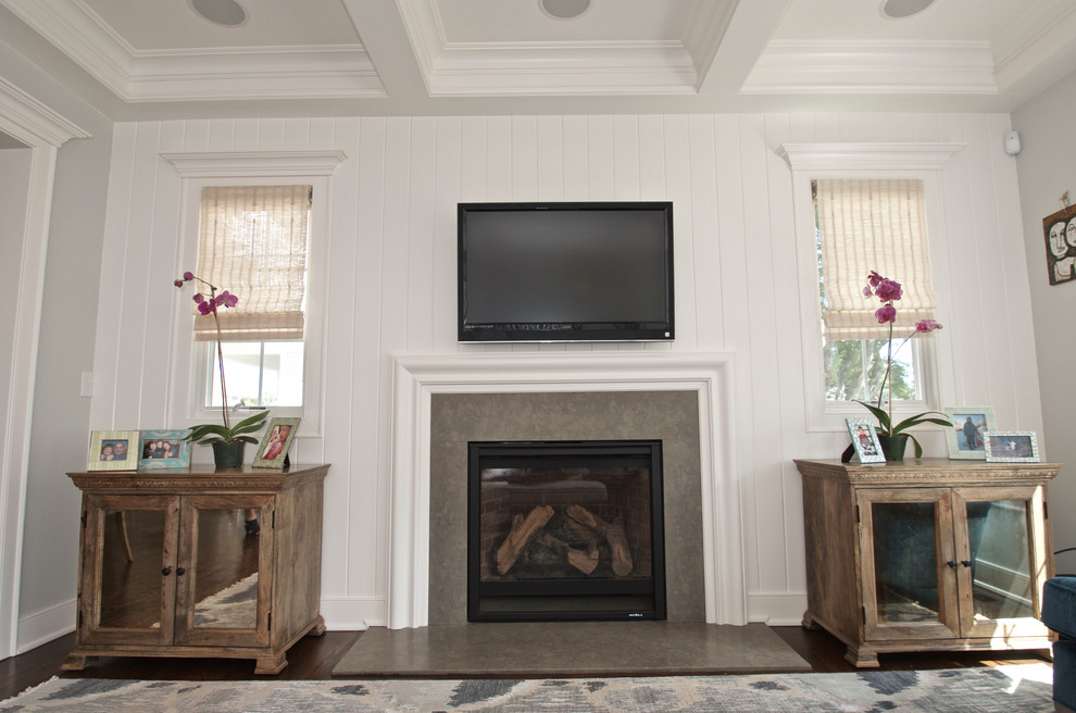 Photo of a mid-sized transitional open concept family room in New York with white walls, dark hardwood floors, a standard fireplace, a stone fireplace surround and a wall-mounted tv.