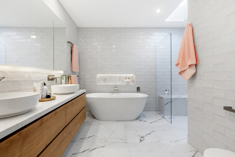 Design ideas for a contemporary bathroom in Melbourne with flat-panel cabinets, medium wood cabinets, a freestanding tub, a vessel sink, white floor, white benchtops, a niche, a double vanity and a floating vanity.