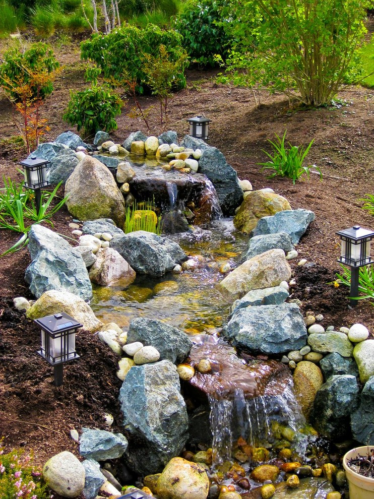 Inspiration for a mid-sized rustic full sun backyard stone water fountain landscape in Seattle for spring.
