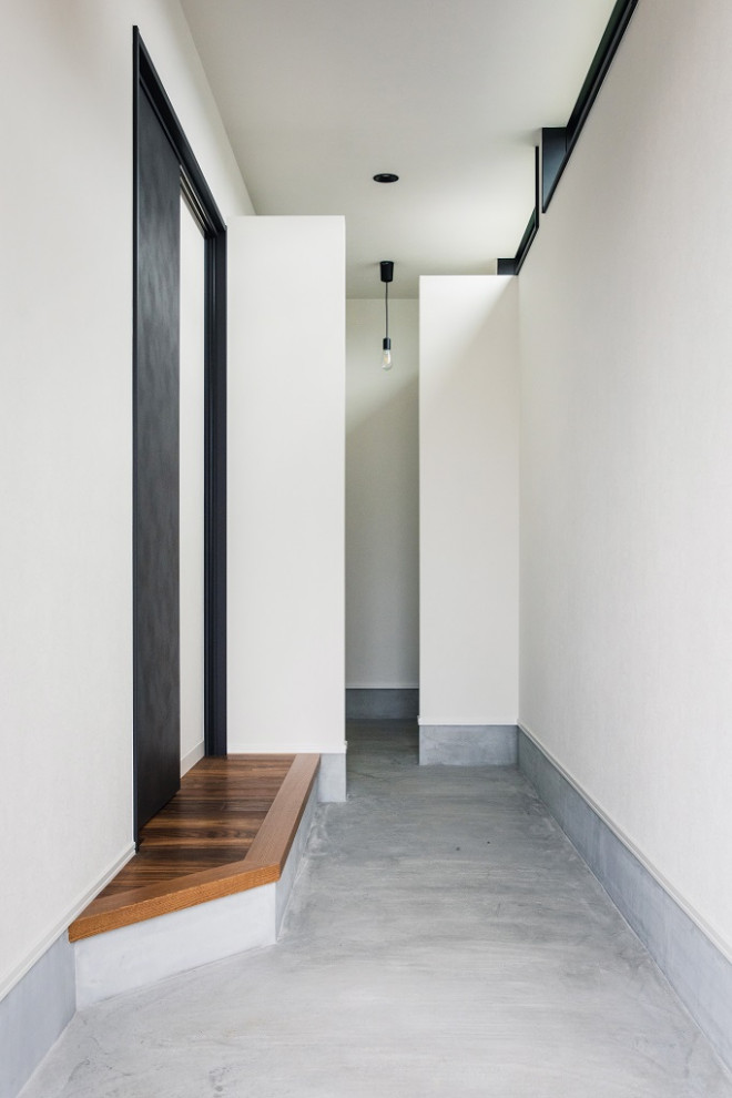Diseño de entrada blanca urbana con paredes blancas, suelo de madera oscura, suelo marrón, papel pintado y machihembrado
