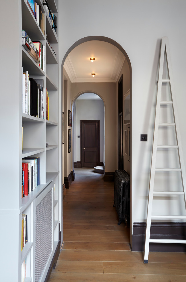 Photo of a modern hallway in London with white walls and medium hardwood floors.