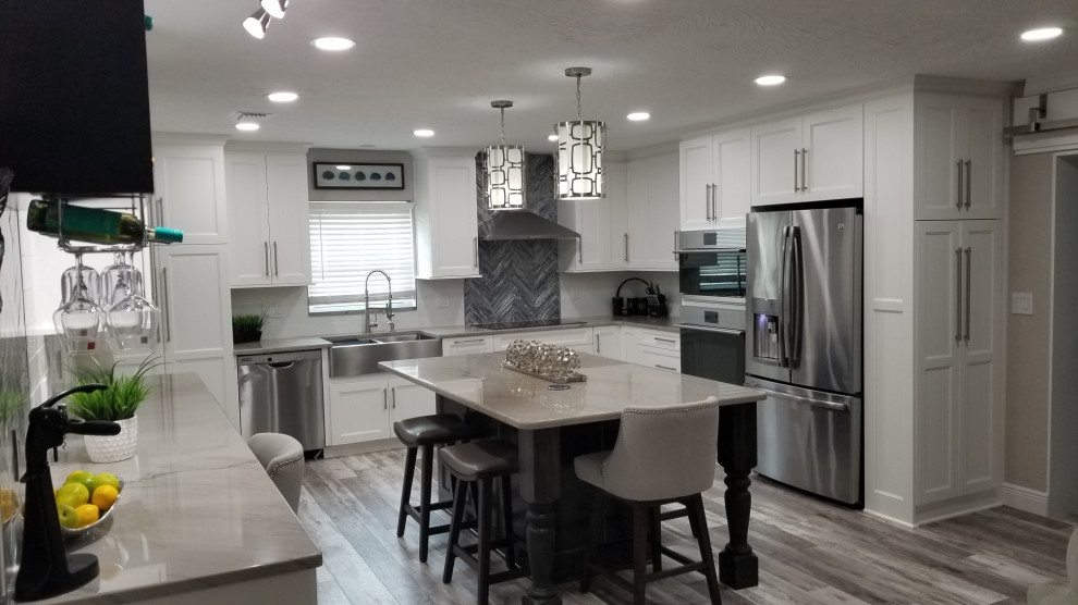 This is an example of a large classic u-shaped kitchen/diner in Tampa with white cabinets and an island.
