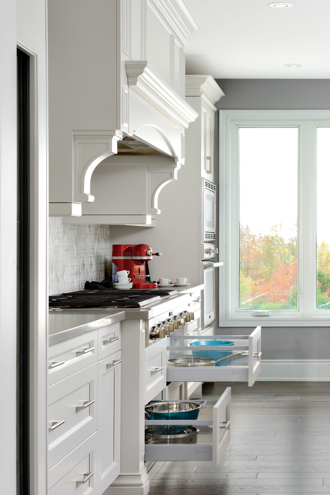 Large transitional l-shaped medium tone wood floor and brown floor open concept kitchen photo in Toronto with an undermount sink, recessed-panel cabinets, quartz countertops, gray backsplash, paneled appliances, an island, gray cabinets and marble backsplash