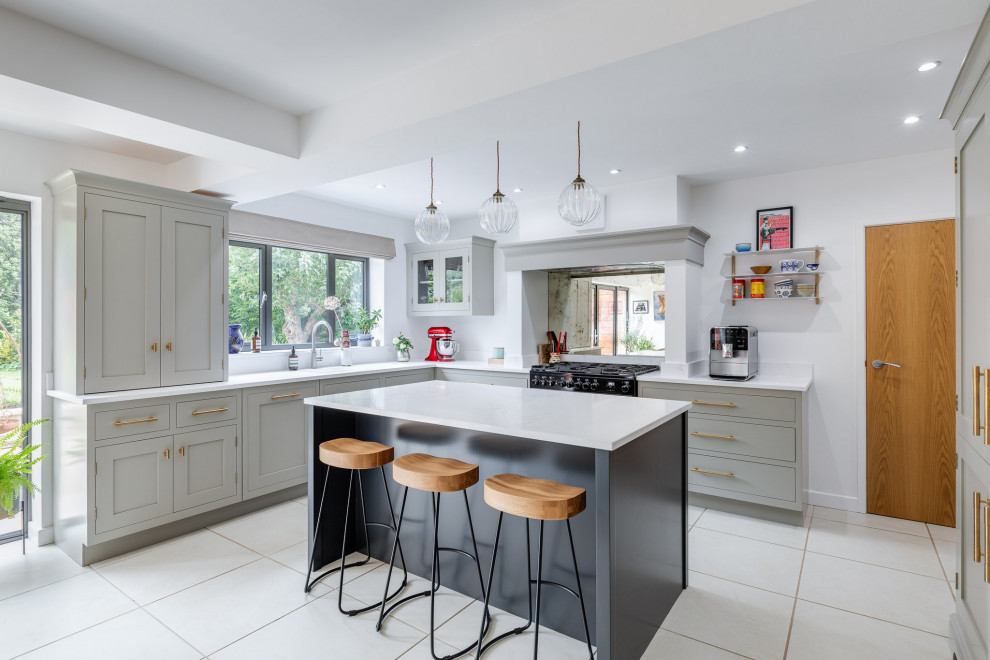 Huge elegant l-shaped limestone floor and white floor eat-in kitchen photo in Hertfordshire with a single-bowl sink, raised-panel cabinets, gray cabinets, quartzite countertops, metallic backsplash, mirror backsplash, an island and white countertops
