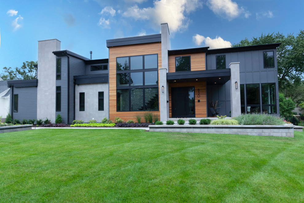 Cette photo montre une façade de maison multicolore tendance en planches et couvre-joints à un étage avec un revêtement mixte, un toit en shingle et un toit noir.