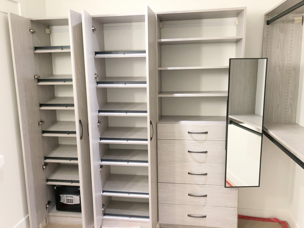Idée de décoration pour un grand dressing design en bois clair neutre.