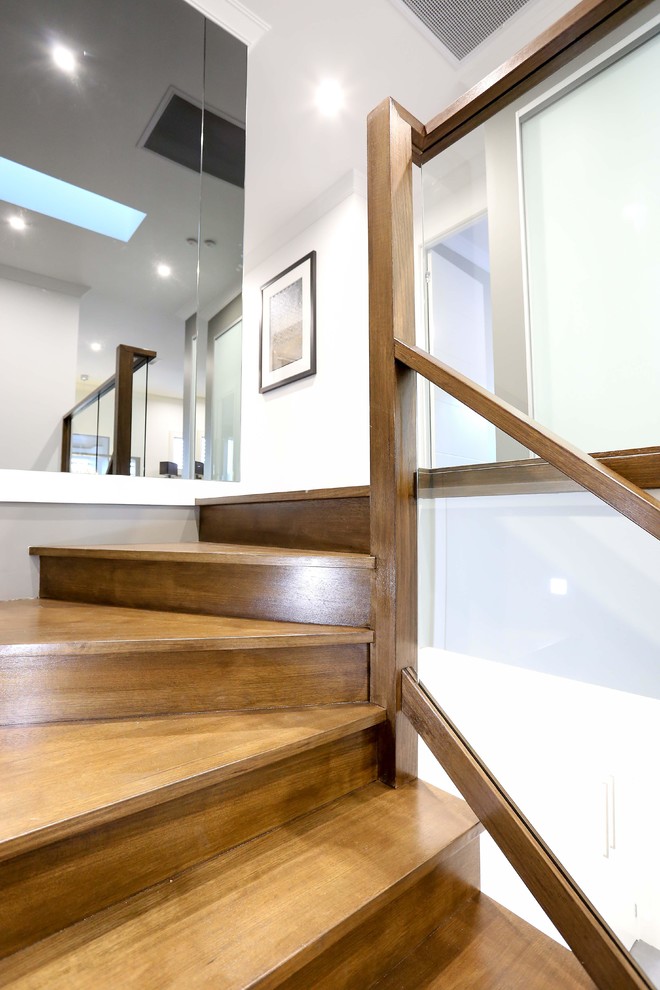 This is an example of a mid-sized contemporary wood straight staircase in Sydney with wood risers.