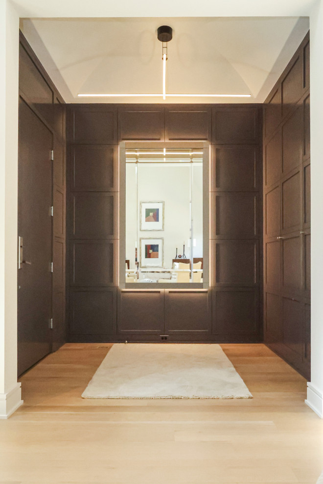 Transitional entryway in Other with black walls, light hardwood floors and panelled walls.