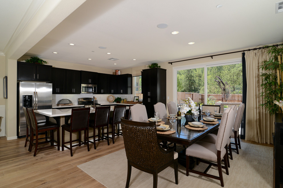 This is an example of a mid-sized transitional open plan dining in Sacramento with beige walls and light hardwood floors.