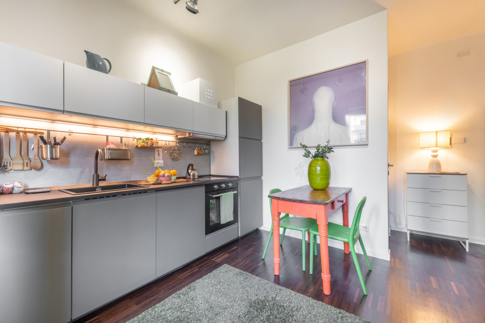 Kleines, Offenes Modernes Wohnzimmer mit weißer Wandfarbe, dunklem Holzboden und braunem Boden in Mailand