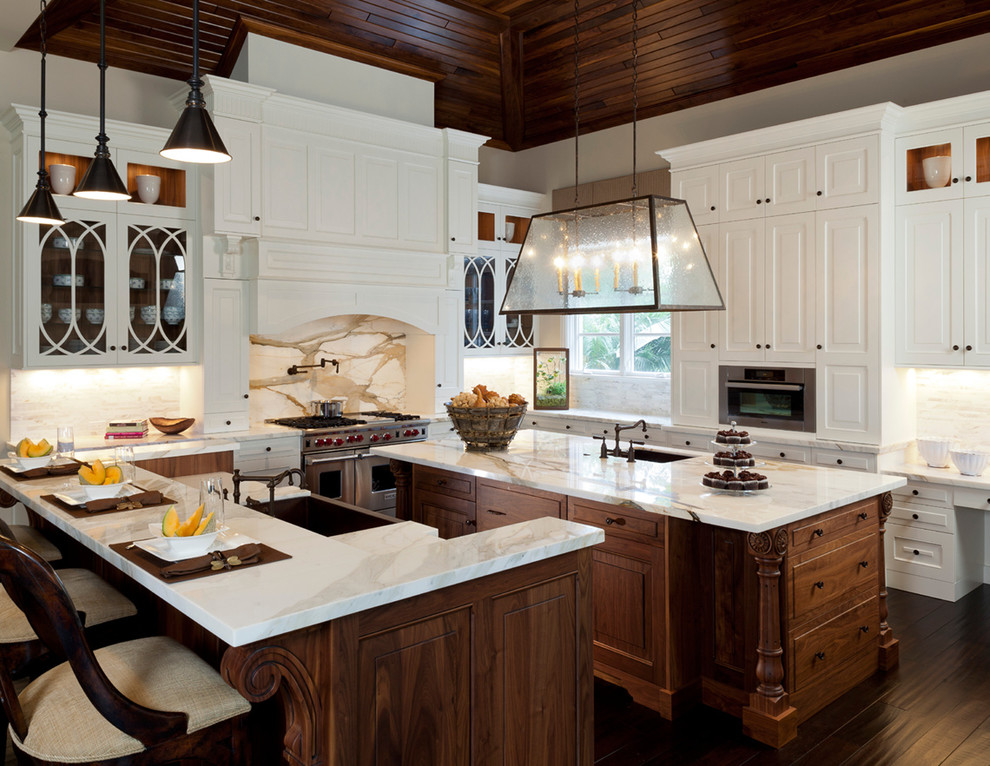 Mountain style u-shaped eat-in kitchen photo in Miami with a farmhouse sink, raised-panel cabinets, white cabinets, marble countertops, multicolored backsplash, stone slab backsplash, stainless steel appliances, beige walls, engineered wood floors and an island