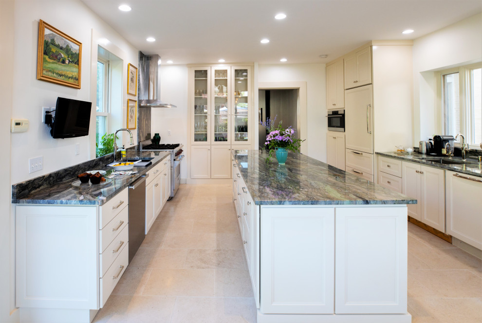 Inspiration for a large transitional kitchen in Philadelphia with an undermount sink, raised-panel cabinets, white cabinets, granite benchtops, panelled appliances, limestone floors, with island, beige floor and green benchtop.