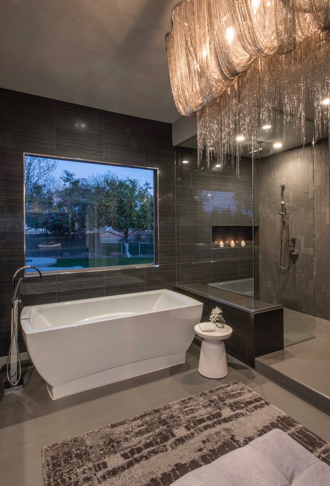 Expansive contemporary master bathroom in Phoenix with flat-panel cabinets, medium wood cabinets, a freestanding tub, a corner shower, a one-piece toilet, gray tile, porcelain tile, grey walls, porcelain floors, a vessel sink, engineered quartz benchtops, grey floor and an open shower.