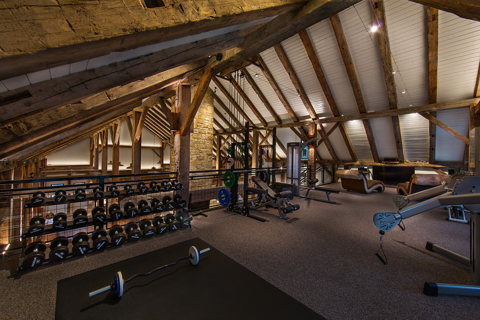 This is an example of a large country home weight room in Austin with white walls, carpet and grey floor.