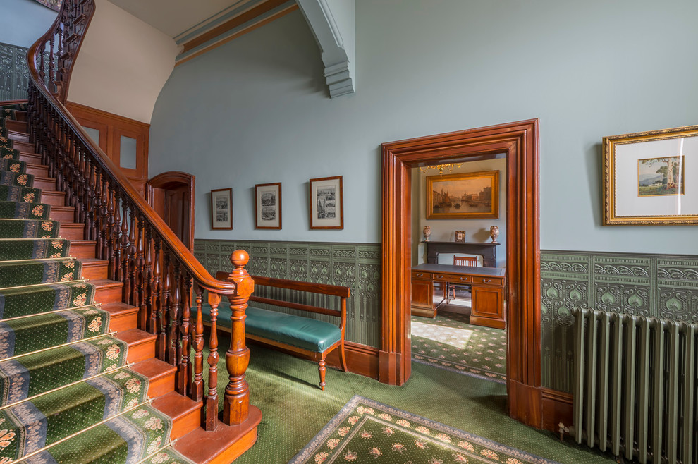This is an example of a traditional foyer in Melbourne with blue walls and carpet.