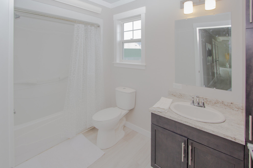 Design ideas for a mid-sized traditional kids bathroom in Other with shaker cabinets, grey cabinets, an alcove tub, an alcove shower, a one-piece toilet, beige tile, beige walls, laminate floors, a drop-in sink, laminate benchtops, beige floor, a shower curtain, beige benchtops, a single vanity and a built-in vanity.