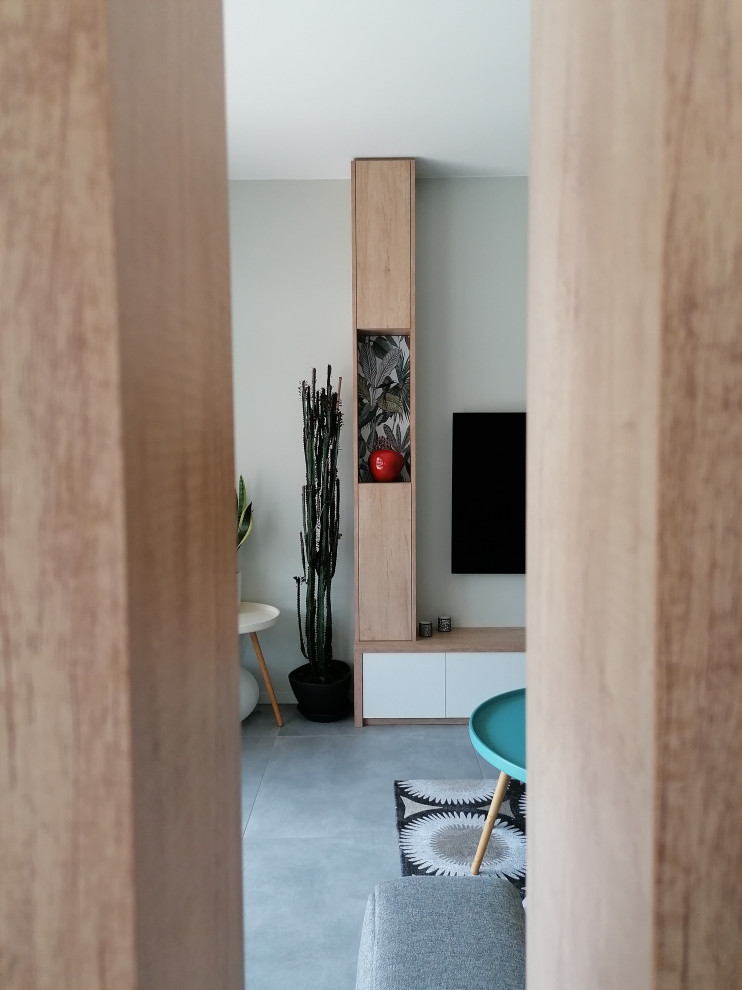 Cette photo montre une salle de séjour scandinave de taille moyenne et ouverte avec un mur vert, un sol en carrelage de céramique, un téléviseur fixé au mur, un sol gris et du papier peint.