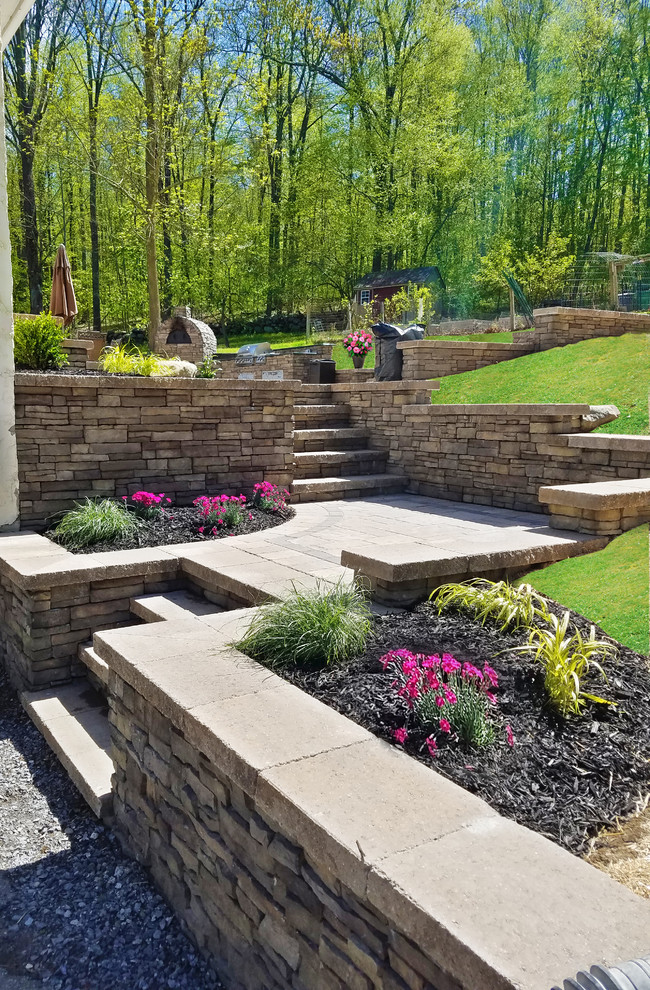 Large contemporary backyard full sun garden in New York with natural stone pavers.