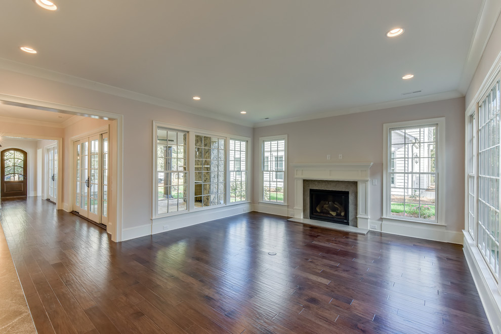 Large transitional open concept medium tone wood floor home design photo in Charlotte with white walls, a standard fireplace and a stone fireplace