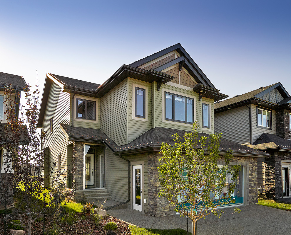 Inspiration for a traditional two-storey green exterior in Edmonton with vinyl siding.