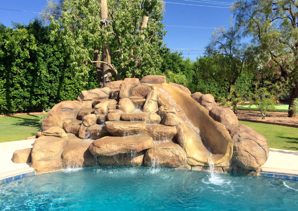 Design ideas for a mid-sized country backyard custom-shaped natural pool in Phoenix with a water feature and stamped concrete.