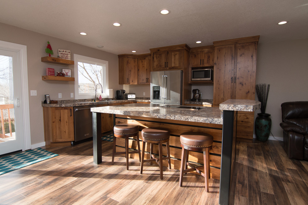 Example of a mid-sized mountain style l-shaped medium tone wood floor and brown floor eat-in kitchen design in Denver with an undermount sink, shaker cabinets, medium tone wood cabinets, quartz countertops, black appliances, an island and multicolored countertops