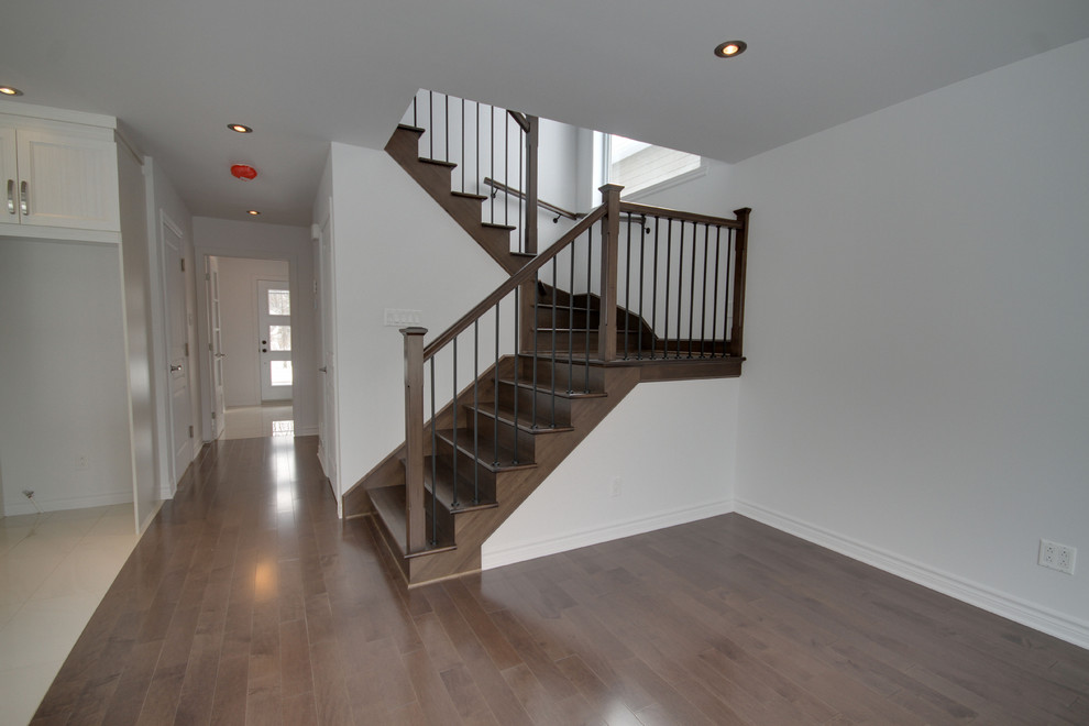 This is an example of a mid-sized contemporary wood u-shaped staircase in Montreal with wood risers.