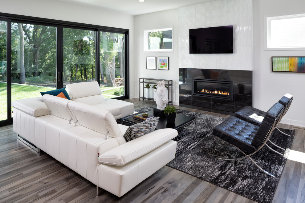 Design ideas for a mid-sized contemporary open concept living room in Minneapolis with white walls, a ribbon fireplace, a tile fireplace surround, a wall-mounted tv, medium hardwood floors and brown floor.