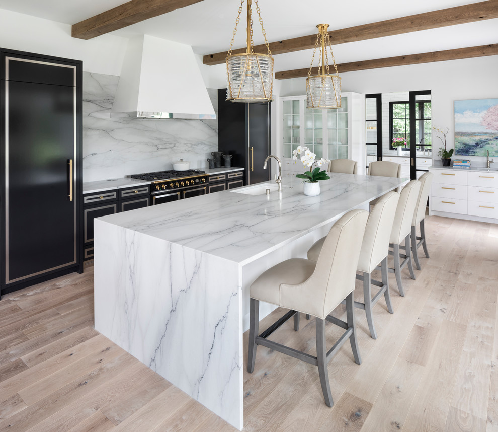 Inspiration for a contemporary kitchen in Minneapolis with an undermount sink, marble benchtops, white splashback, marble splashback, black appliances, light hardwood floors, with island, beige floor and white benchtop.