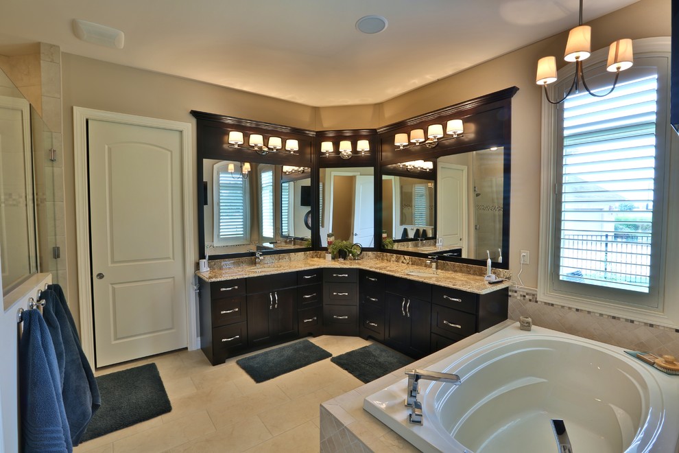 Inspiration for a mid-sized traditional master bathroom in Chicago with an undermount sink, raised-panel cabinets, dark wood cabinets, granite benchtops, a drop-in tub, an alcove shower, a two-piece toilet, beige tile, stone tile, beige walls and porcelain floors.