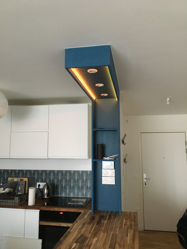 Einzeilige, Mittelgroße Moderne Küche mit Kassettenfronten, blauen Schränken und Kücheninsel in Paris