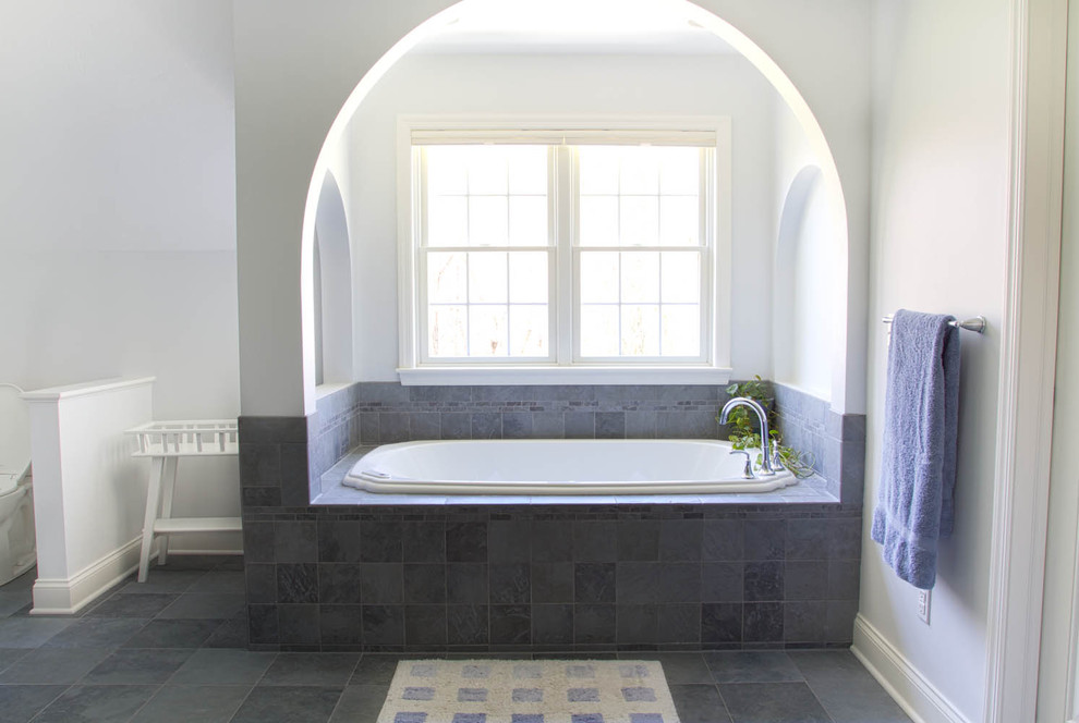 Contemporary bathroom with a drop-in tub and gray tile.