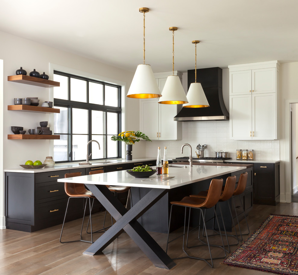 Inspiration for a transitional u-shaped eat-in kitchen in Chicago with an undermount sink, shaker cabinets, black cabinets, white splashback, medium hardwood floors, with island and brown floor.