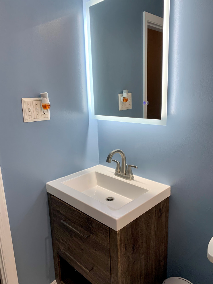 Ispirazione per una piccola stanza da bagno contemporanea con ante lisce, ante in legno scuro, pareti blu, lavabo integrato, top in superficie solida, top bianco, un lavabo e mobile bagno freestanding