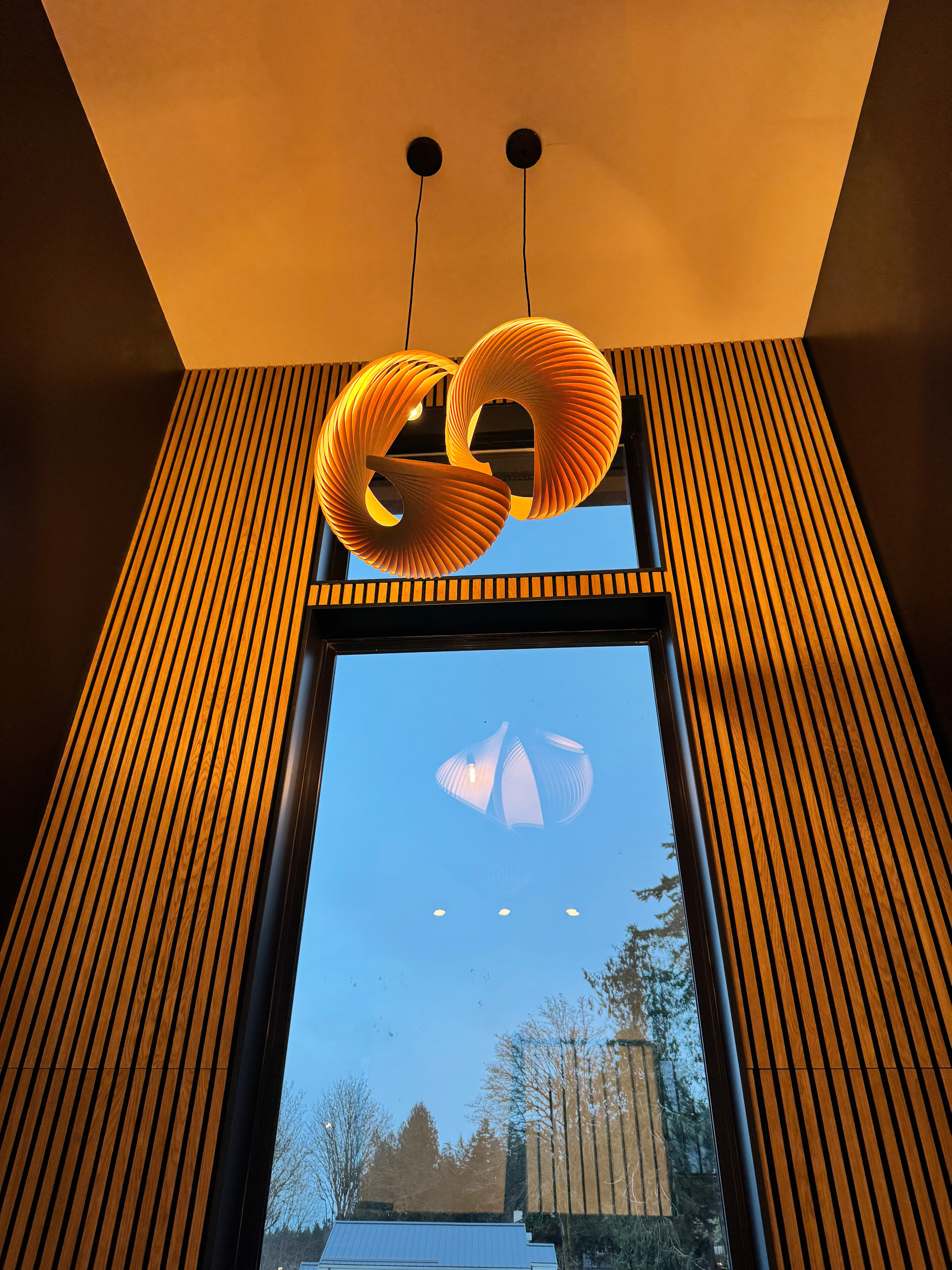 This staircase showcases the impact of thoughtful architectural lighting and custom detailing. A statement pendant light, designed in collaboration with a lighting architect, sets the tone for the spa