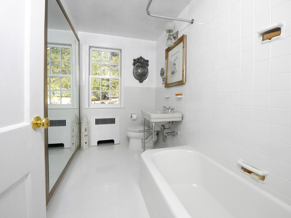 Design ideas for a traditional bathroom in New York with a shower/bathtub combo, gray tile, white walls, a pedestal sink and grey floor.