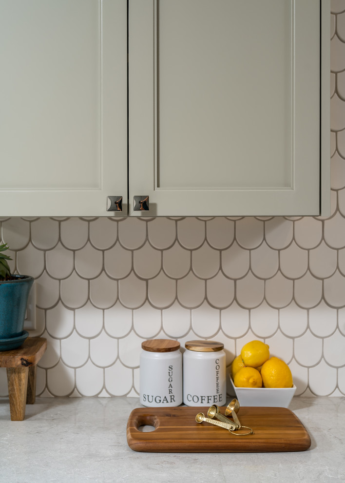 Large transitional u-shaped porcelain tile enclosed kitchen photo with an undermount sink, shaker cabinets, gray cabinets, quartz countertops, white backsplash, ceramic backsplash, stainless steel appliances and a peninsula