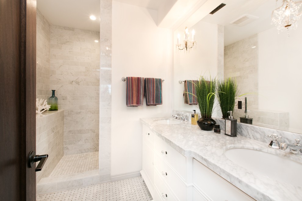 Inspiration for a large mediterranean master bathroom in Los Angeles with flat-panel cabinets, white cabinets, an alcove shower, white tile, stone tile, white walls, marble floors, an undermount sink and marble benchtops.