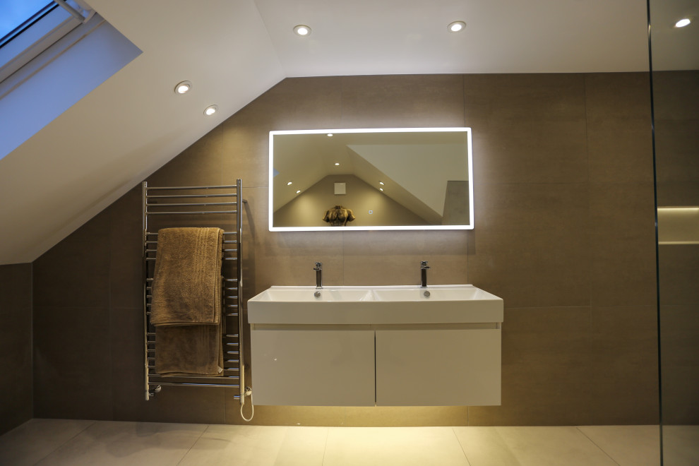 Large contemporary family bathroom in Hertfordshire with grey cabinets, a freestanding bath, a walk-in shower, a wall mounted toilet, grey tiles, ceramic tiles, grey walls, porcelain flooring, a wall-mounted sink, grey floors, an open shower, double sinks and a floating vanity unit.