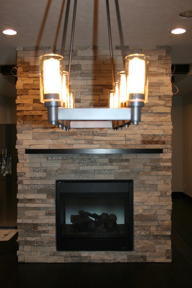 Inspiration for a mid-sized transitional dark wood floor and brown floor kitchen/dining room combo remodel with recessed-panel cabinets, dark wood cabinets, glass tile backsplash, stainless steel appliances, an island, a two-sided fireplace, a stone fireplace and beige walls